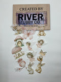 Forest fairy themed edible wafer paper cake charms including fairies, woodland animals and mushrooms arranged below a Riverside Stubby Co wooden sign