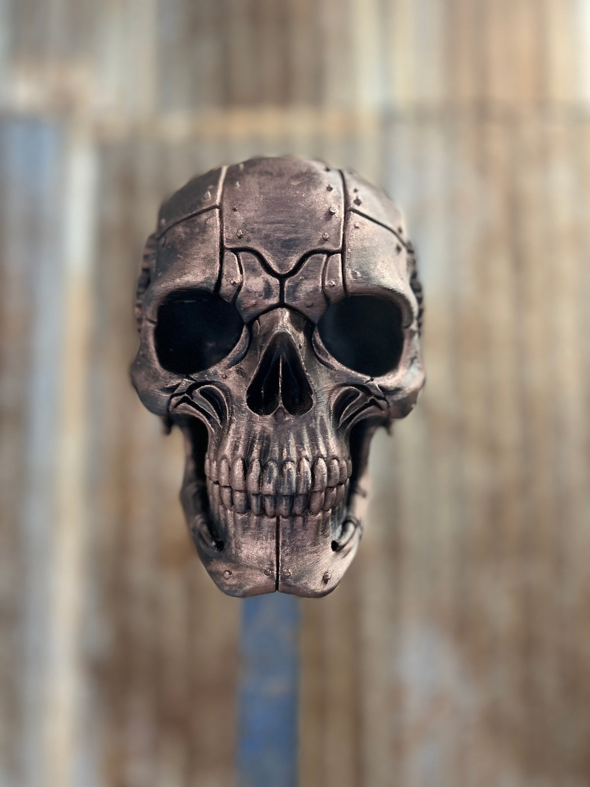 Black leather open face motorcycle helmet hanging on the steampunk skull helmet stand